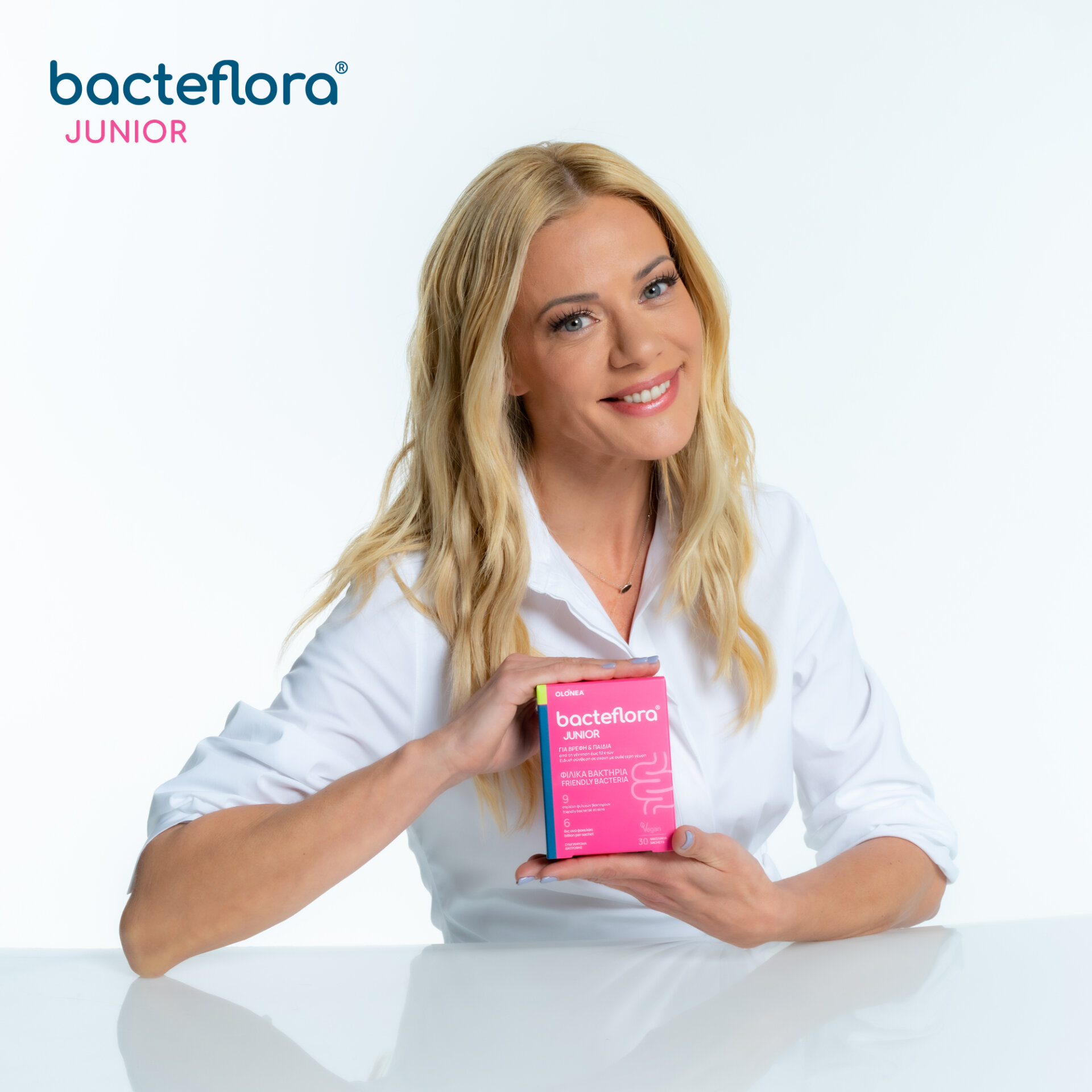 Η Ζέτα Μακρυπούλια, το «πρόσωπο» της OLONEA, κρατάει στα χέρια της μια συσκευασία του συμπληρώματος προβιοτικών bacteflora® JUNIOR της OLONEA, για βρέφη και παιδιά.