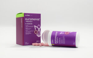 Ouromanoz Protect D-Mannose supplement box and bottle with pink pills spilled in front on a white background.