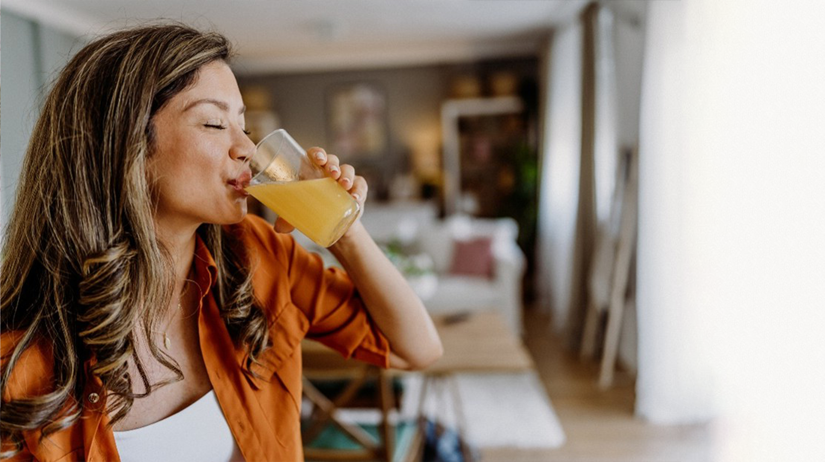 Μια γυναίκα που πίνει έναν φυσικό χυμό πλούσιο σε βιταμίνη C, έχοντας καταναλώσει και τα προβιοτικά και άλλα συμπληρώματα της OLONEA, που θα ενισχύσουν το ανοσοποιητικό της.