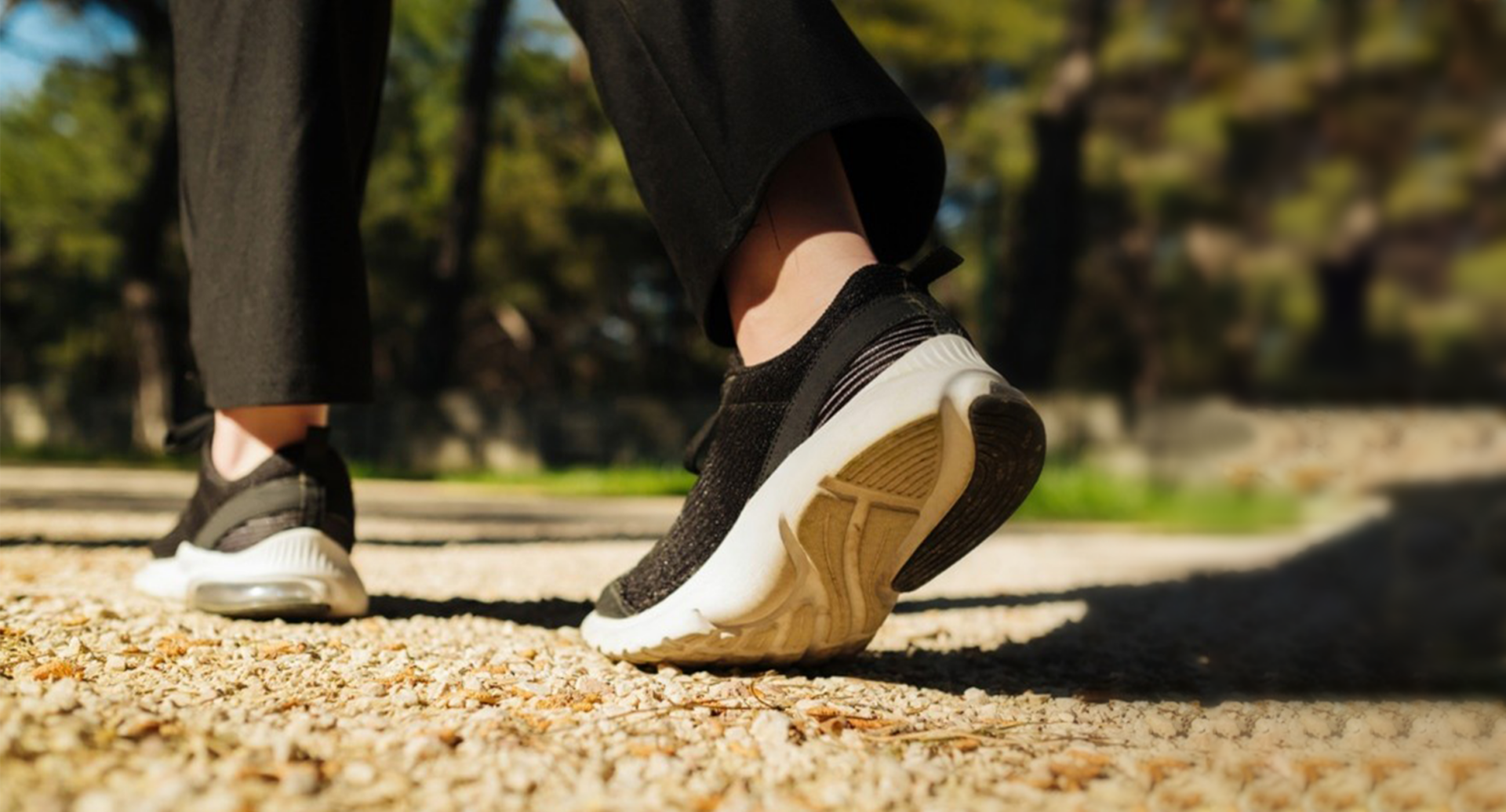 Κοντινό πλάνο στα πόδια ενός ατόμου, το οποίο περπατάει σε ένα πάρκο, θέλοντας να βοηθήσει τον οργανισμό του να λειτουργεί καλύτερα και να είναι πιο υγιής.