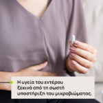 Person in a mauve top holds a small white capsule; overlay text in Greek about gut health and microbiome support: 'Η υγεία του εντέρου ξεκινά από τη σωστή υποστήριξη του μικροβιώματος.'