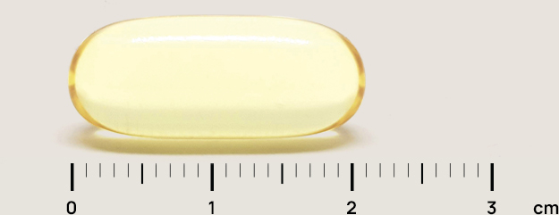 Clear yellow gelatin capsule resting above a centimeter ruler, about 2 cm long.