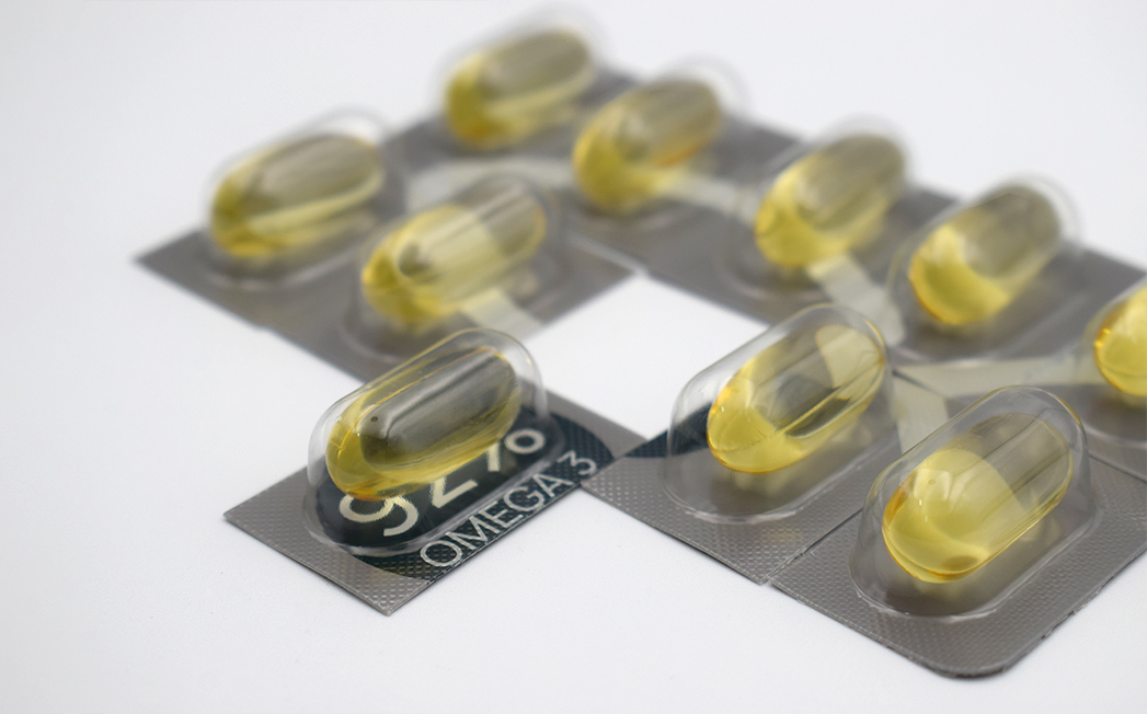 Blister packs containing yellow soft gel capsules labeled Omega-3.